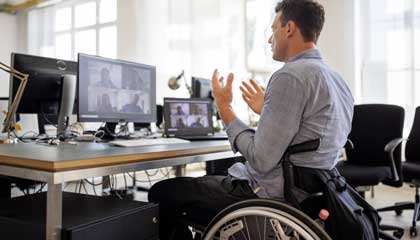 Man in wheelchair in front of online meeting